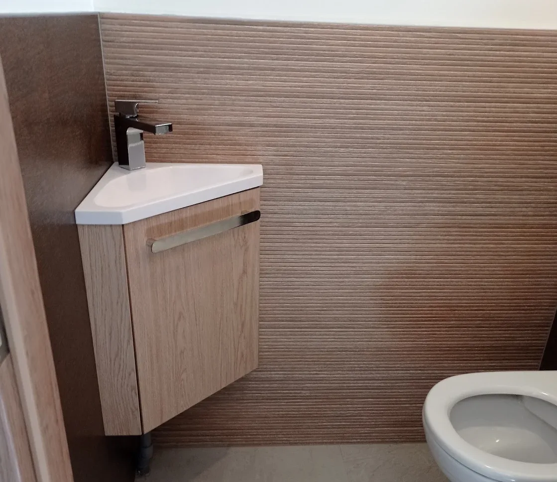 Lave-mains d'angle en céramique sur meuble bois, posé et raccordé par PLOMBERIE SANITAIRE MRZ