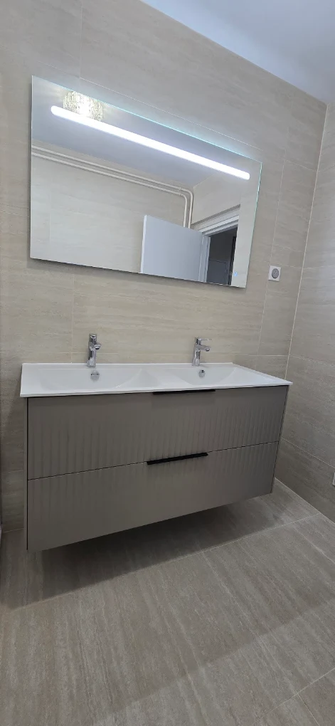 Meuble suspendu double vasque avec miroir rétroéclairé, dans une salle de bain rénovée par PLOMBERIE SANITAIRE MRZ